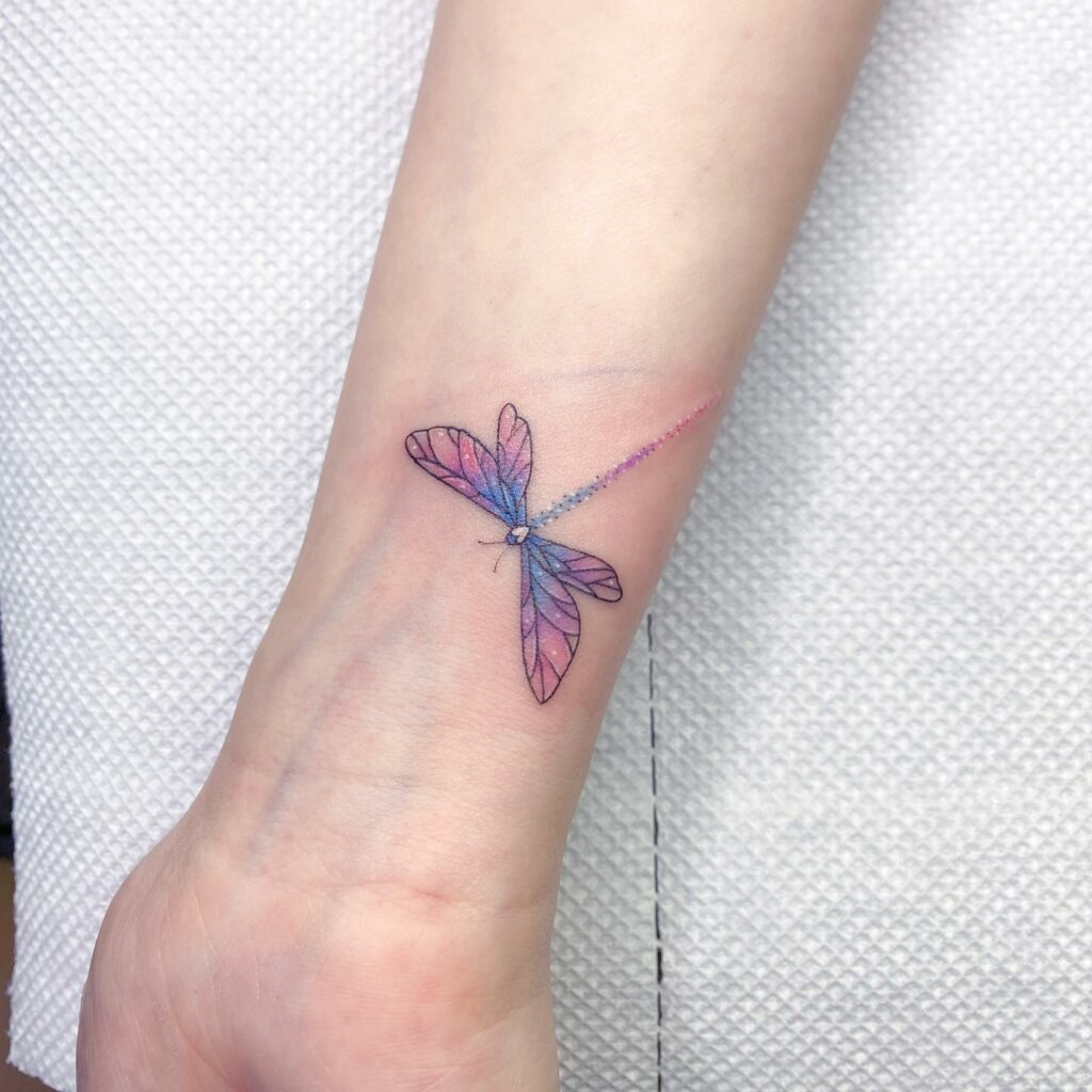 A Colorful Dragonfly Tattoo On The Right Arm And Leg With Words Written Below It