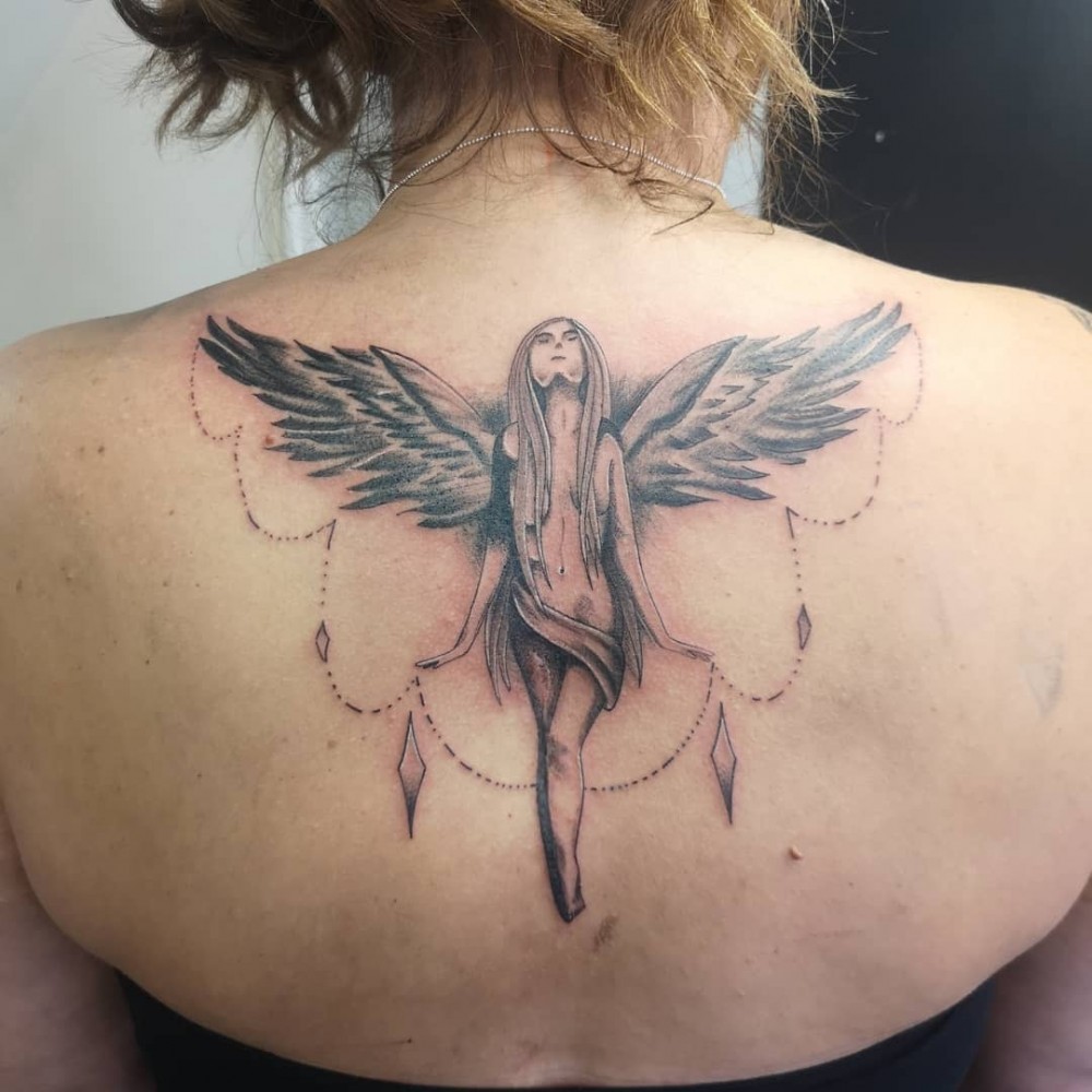 A Woman S Neck With An Angel Wing Tattoo On Her Left Upper Back Side