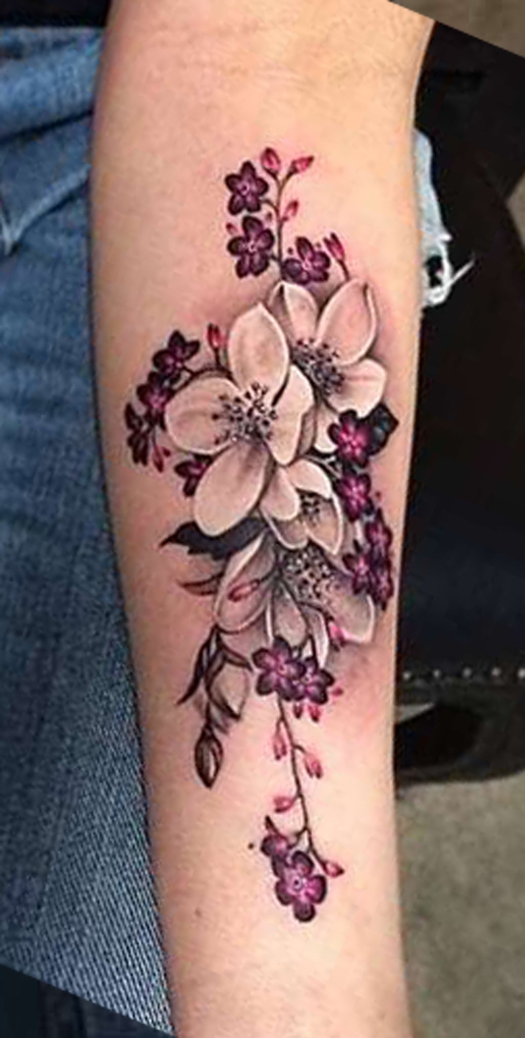 A Woman With A Flower Tattoo On Her Arm