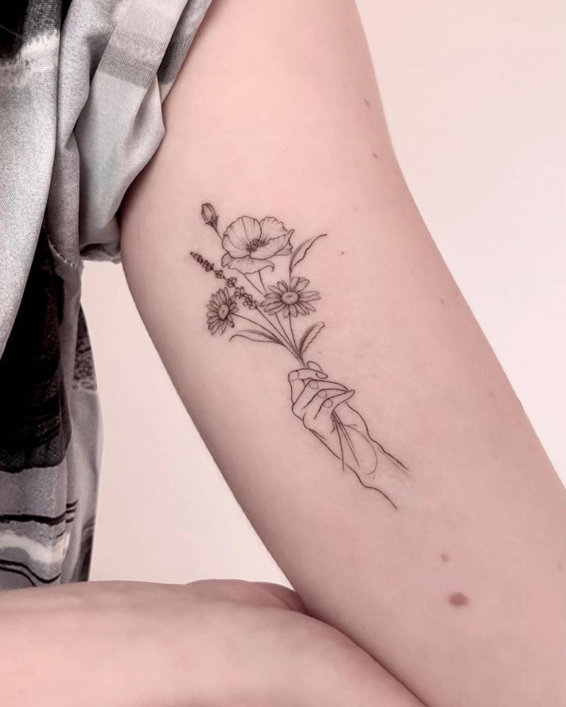 Fine Line Hand Holding Flowers Tattoo On The Inner